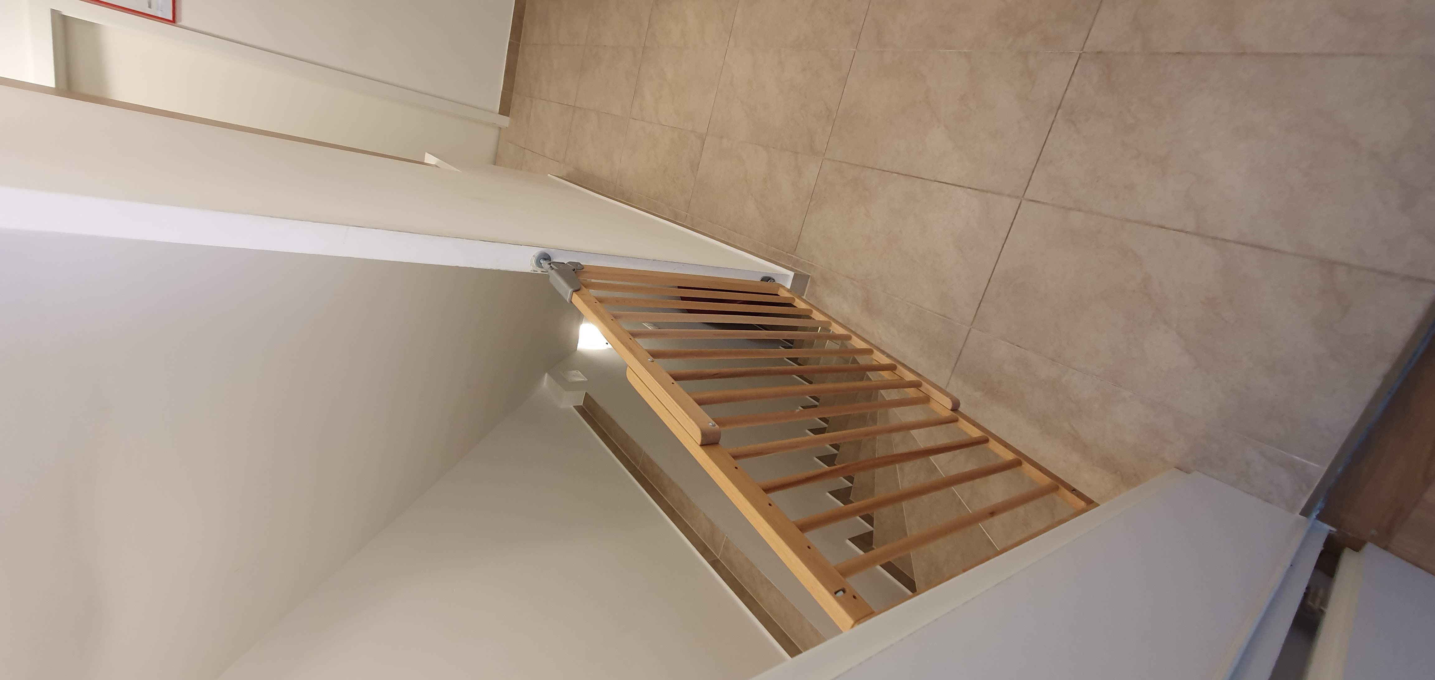 Wooden safety gate at the top of the stairs